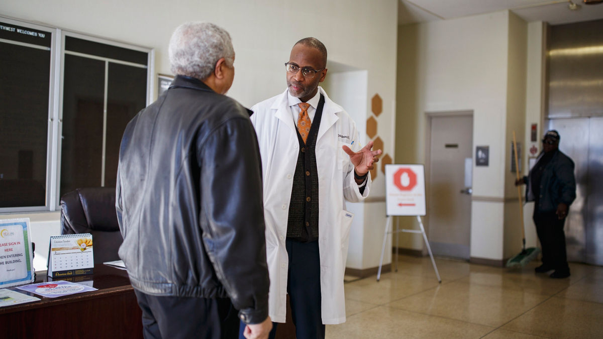 A doctor speaks with a patient at a health clinic.
